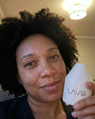 Afro-American woman holding LAVO pod inside her living room